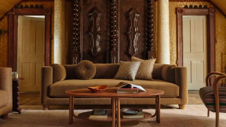 Richly layered living room featuring a low slung moss velvet sofa, intricate woodworking, and two-tier mid-century-style coffee table from Pierce & Ward's second West Elm collaboration