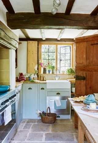 a country kitchen with a galley layout with shaker style cabinetry and aga oven