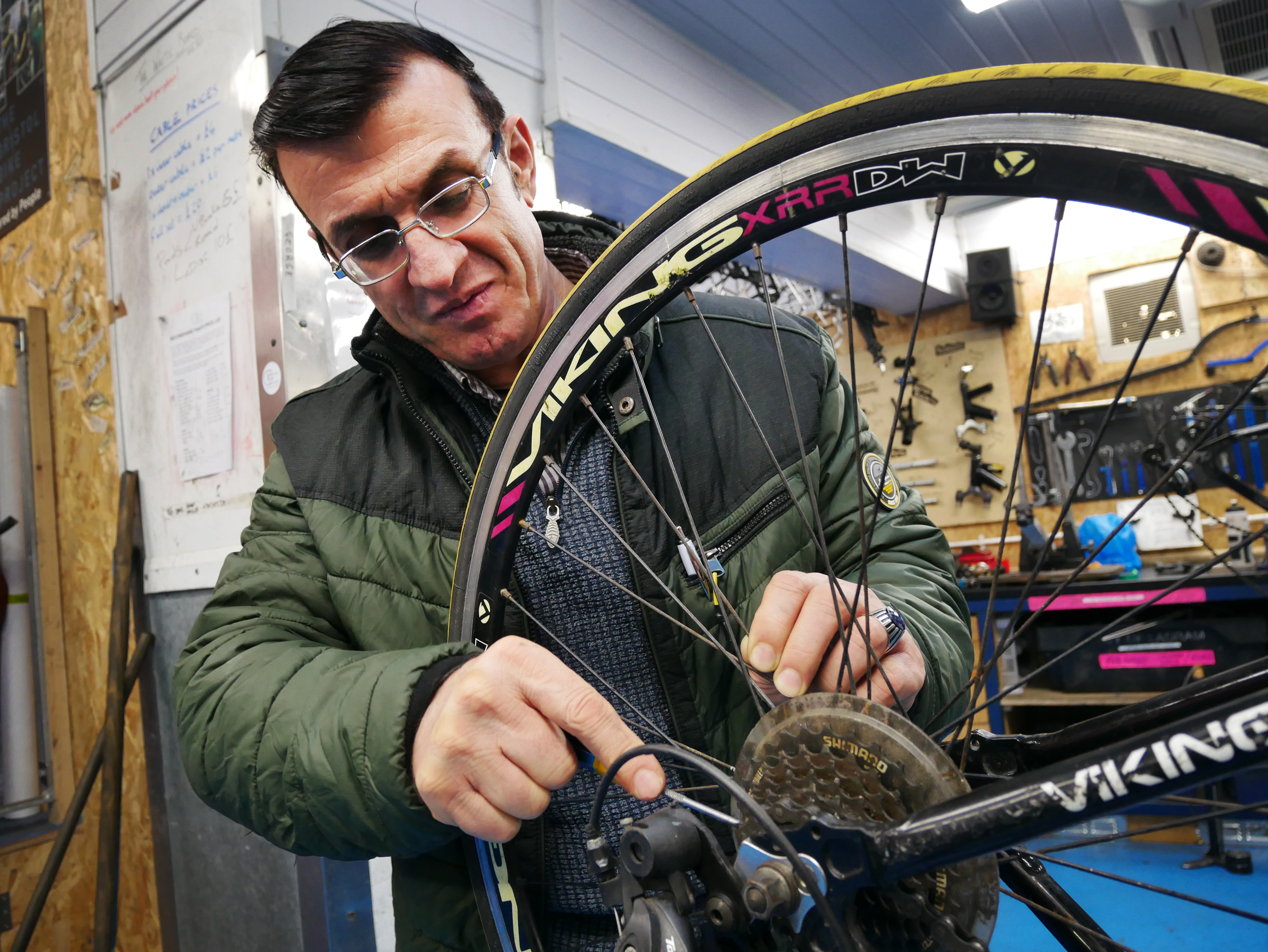 A man looks at a bike wheel