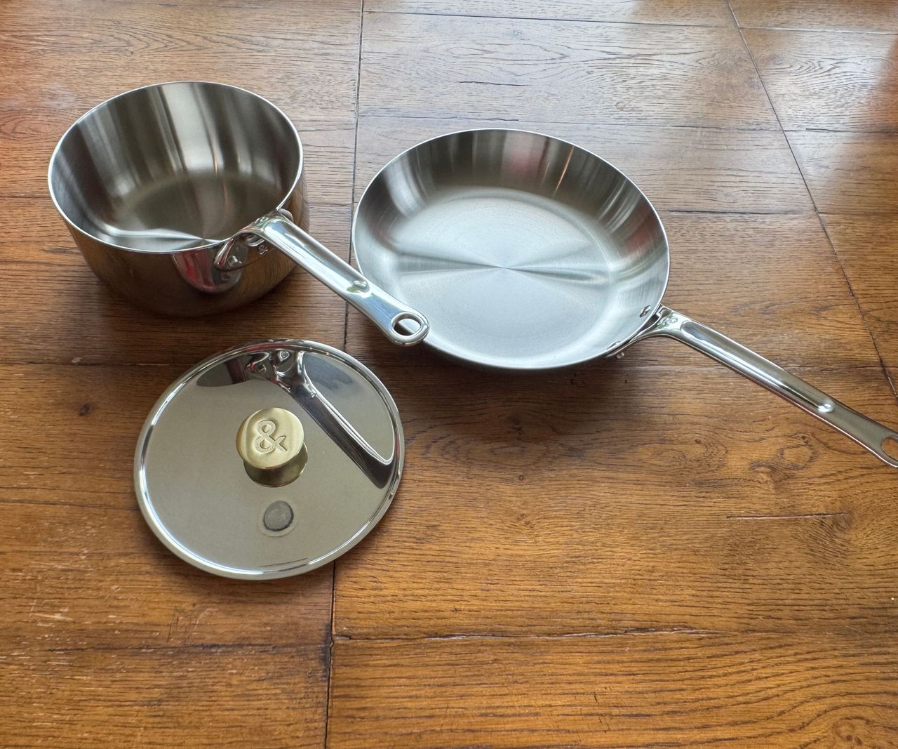 A set of two stainless steel pans, one sauce pan one frying pan