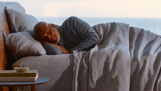 Saatva vs Beautyrest: A man sleeps on the Beautyrest Harmony Lux mattress positioned near the ocean