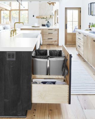 A trash can hidden within a kitchen island