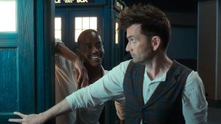 Ncuti Gatwa and David Tennant stand together by the TARDIS doorway in Doctor Who.