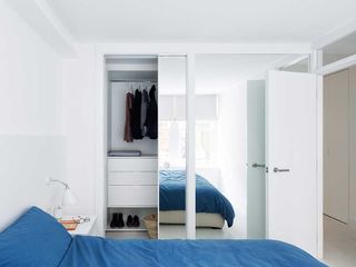 London flat white bedroom blue bedding bespoke walk in wardrobe