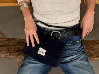 a woman holds a suede handbag