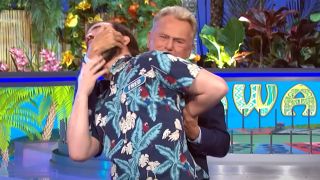 Pat Sajak putting contestant in fake wrestling hold on Wheel of Fortune