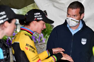 A UCI commissaire talks to Marianne Vos after disqualification during the 2022 Vargarda road race for riding in the 'puppy paws' position