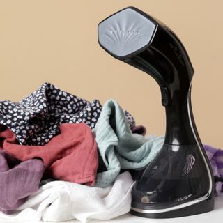 Handheld clothes steamer on tabletop