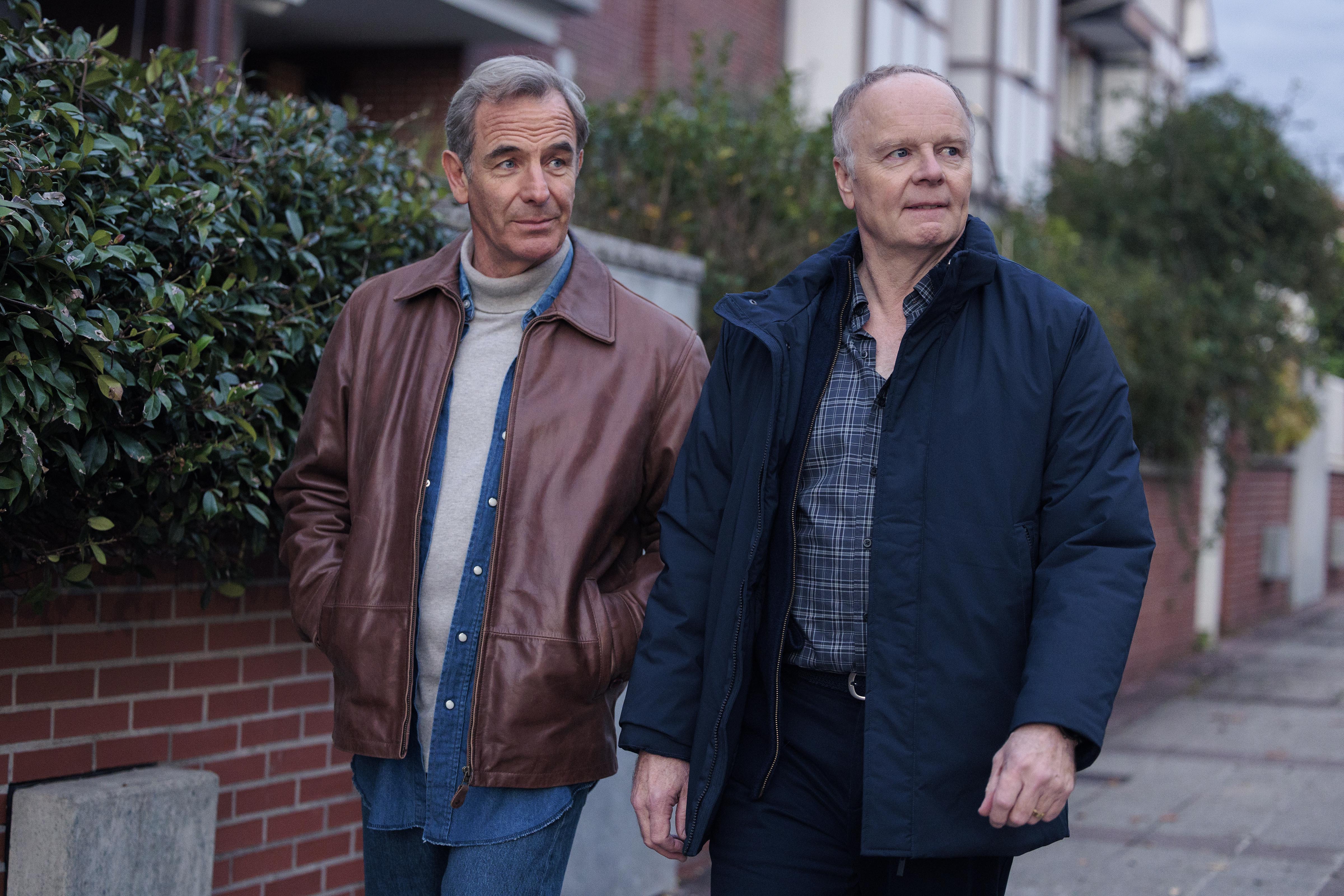 The Game's Patrick Harbottle and Huw Miller walking along the street both looking in the same direction.