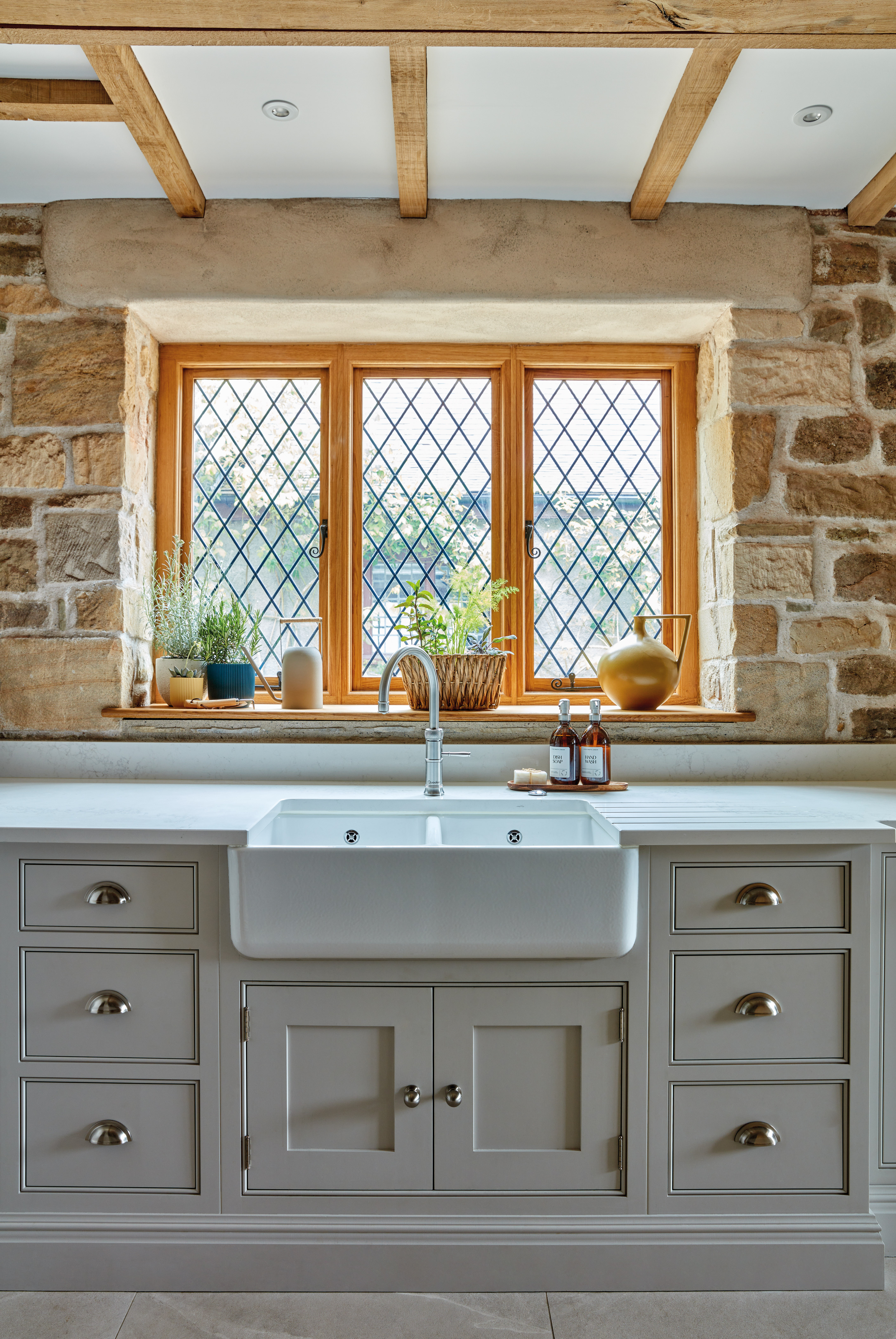 Tom Howley Shaker-style kitchen in grey with a wood-frame lattice window