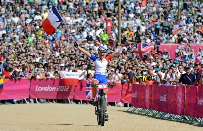 Julie Bresset (France) flies her national flag as she celebrates victory in the women's cross country at the Olympic Games.