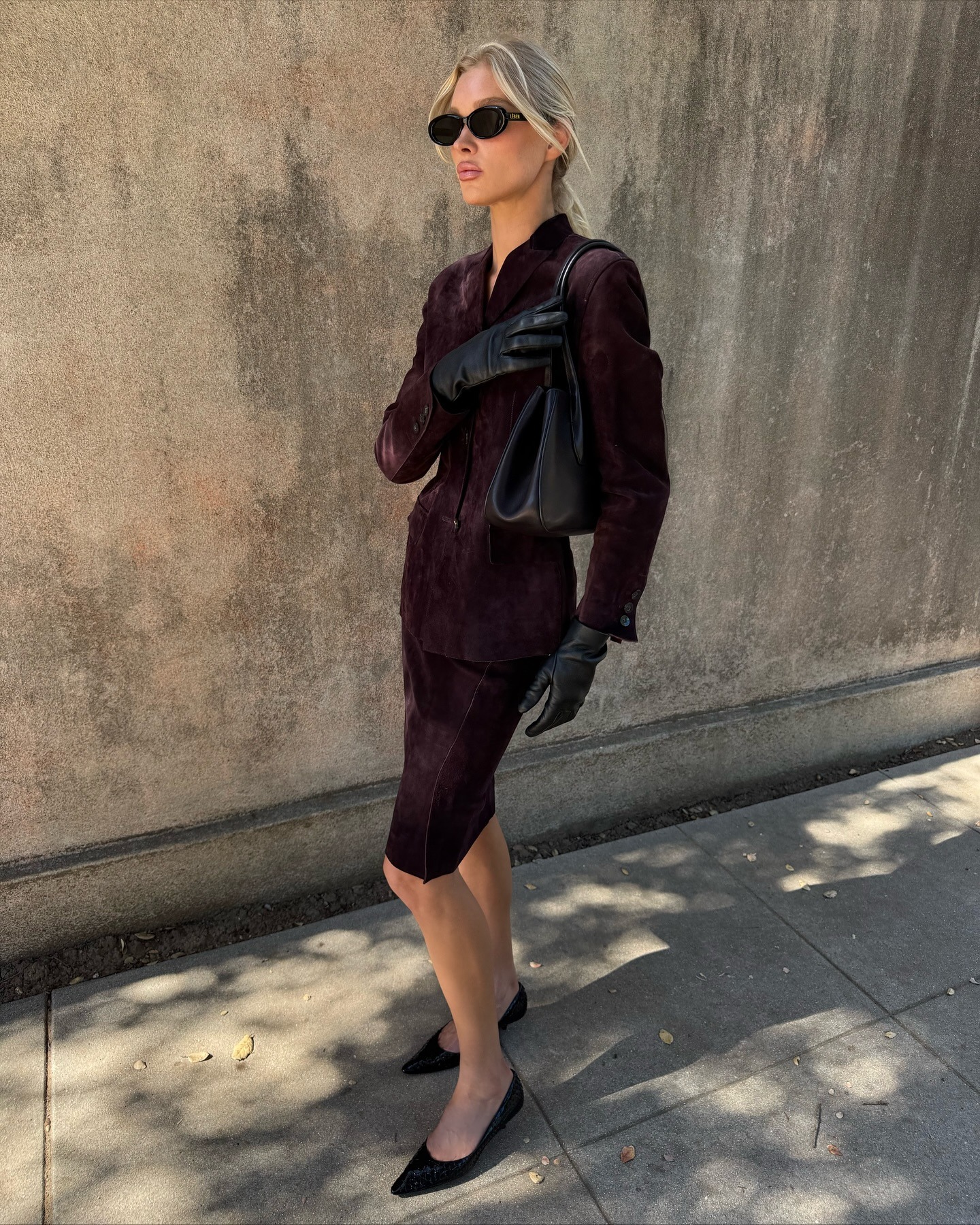 Elsa Hosk wearing a skirt outfit idea for 2026, including a burgundy matching skirt suit.