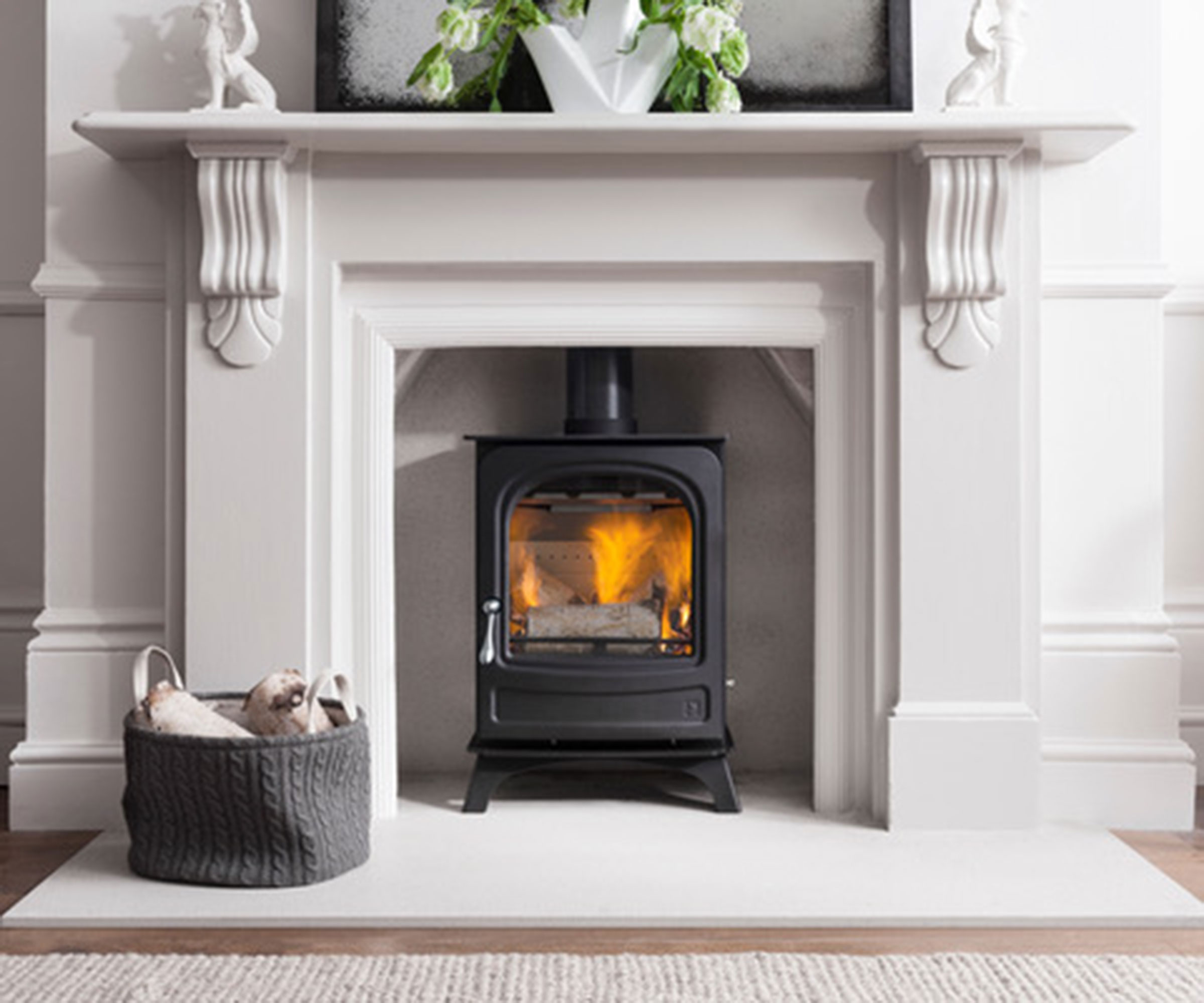 log burning stove within white stone classical fireplace