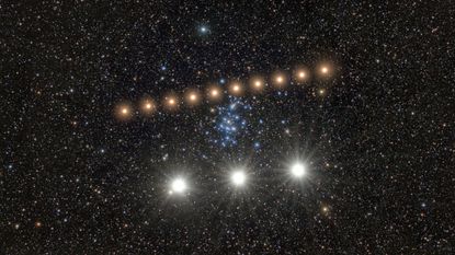 A series of bright golden dots form a diagonal line in the center of a starry night, with three larger whiter dots at the bottom of the image.