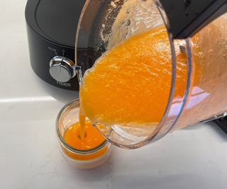 Pouring a carrot juice from the Tiger 45 Degree Diagonal Blade blender in my test kitchen