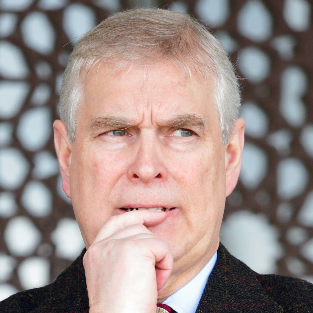 Prince Andrew wearing a black coat and looking anxious 