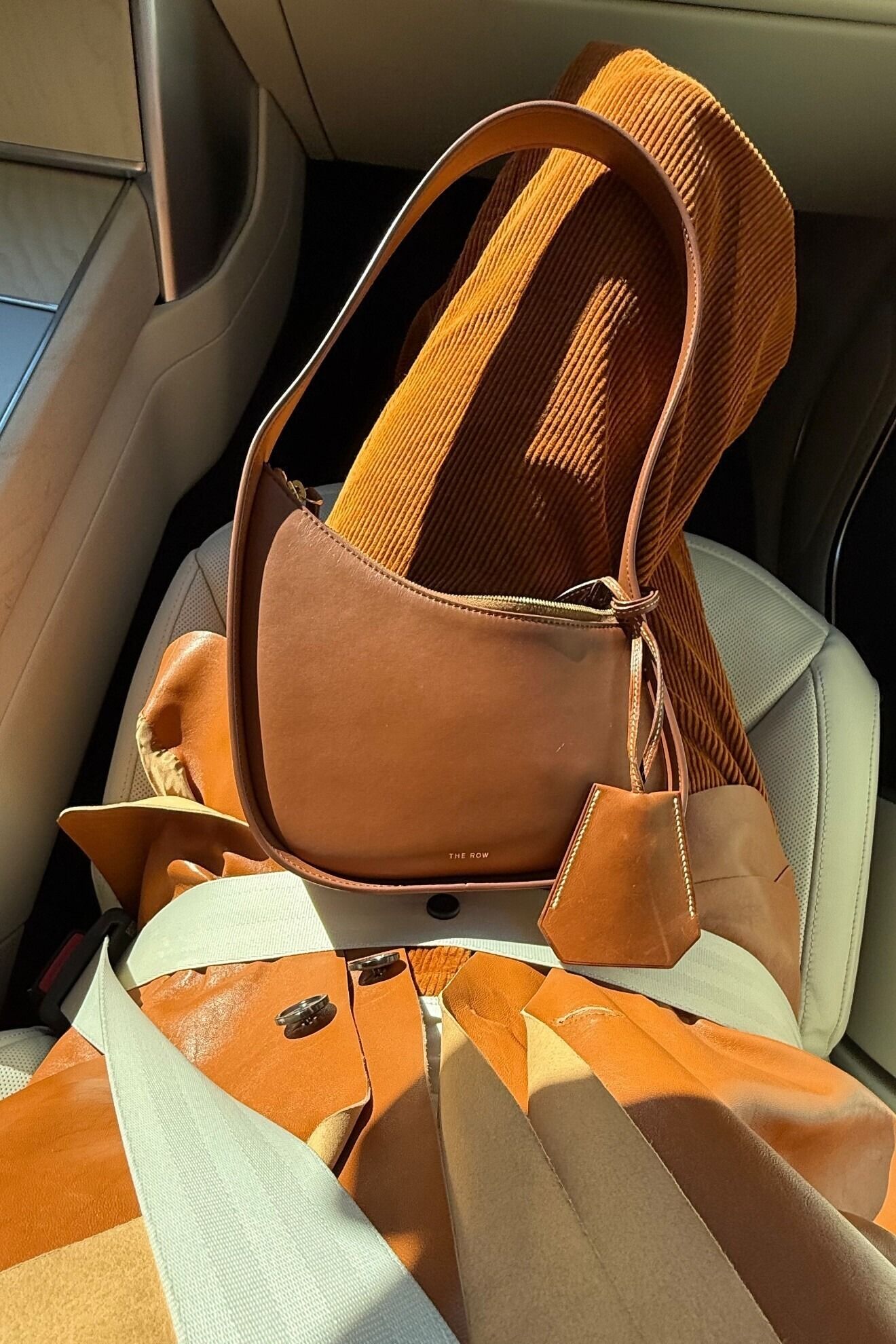 Elsa Hosk with a The Row bag sitting in her lap.
