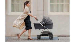 A smartly=dressed woman pushing the Nuna Triv, one of the best pushchairs from our buying guide