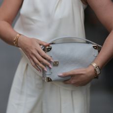 a woman wearing gold rings and neutral nails