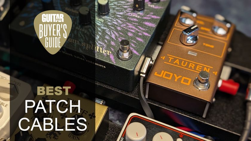 Close up of a patch cable sandwiched between two pedals on a pedalboard