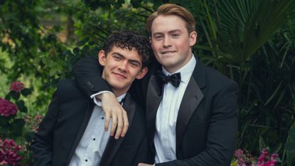 Nick and Charlie wear tuxedos and pose for a photo