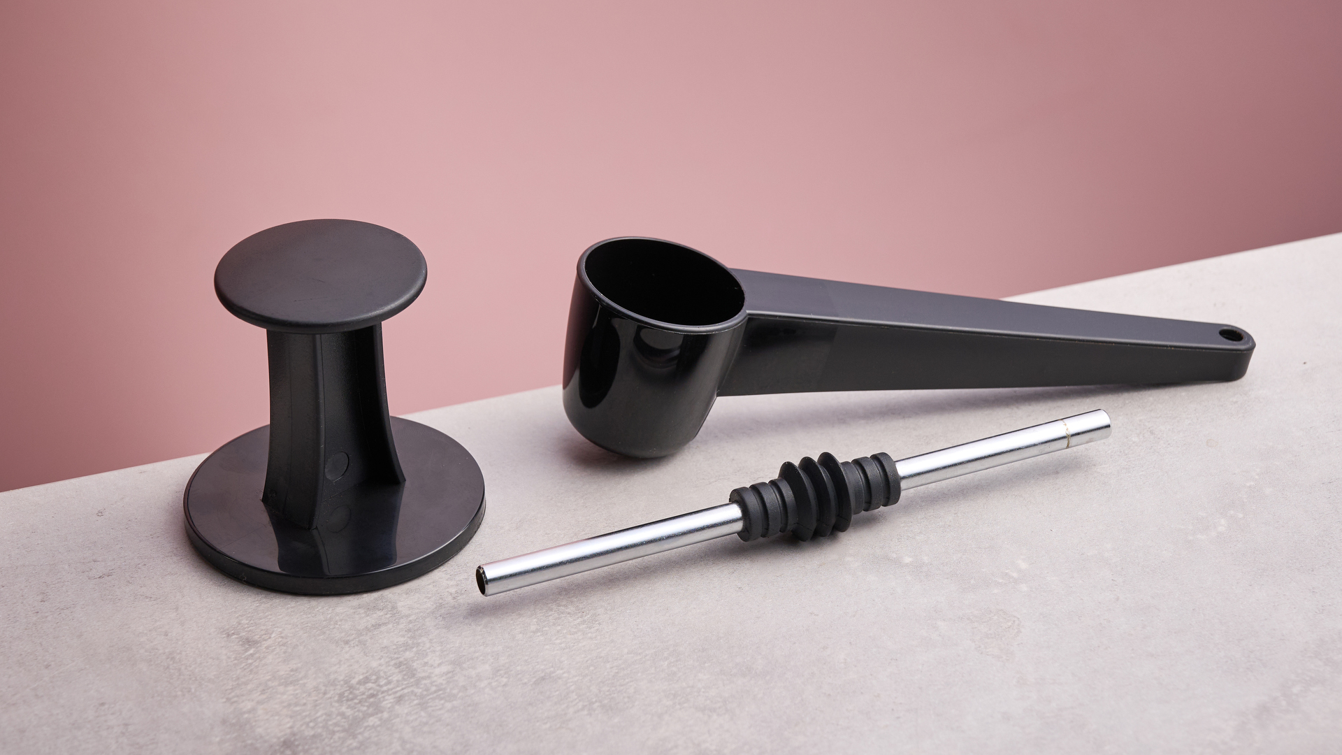 A closeup of the Gaggia Classic E24 Evo Pro&#039;s accessories, including a plastic tamp, a scoop and removeable drain pipe.