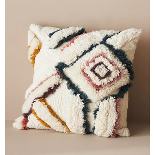 tufted cream pillow with colorful scandi pattern