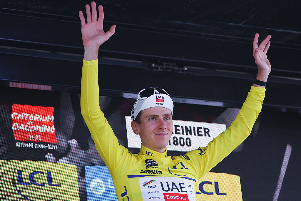 UAE Team Emirates XRG's Slovenian rider Tadej Pogaar celebrates wearing the overall leader's yellow jersey on the podium of the 7th stage of the 77th edition of the Criterium du Dauphine cycling race, 131,6 km between Grand-Aigueblanche and Valmeinier, on June 14, 2025. (Photo by Anne-Christine POUJOULAT / AFP) (Photo by ANNE-CHRISTINE POUJOULAT/AFP via Getty Images)