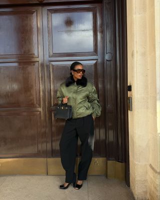 Marilyn Nwawulor Kazemaks wearing a green bomber jacket