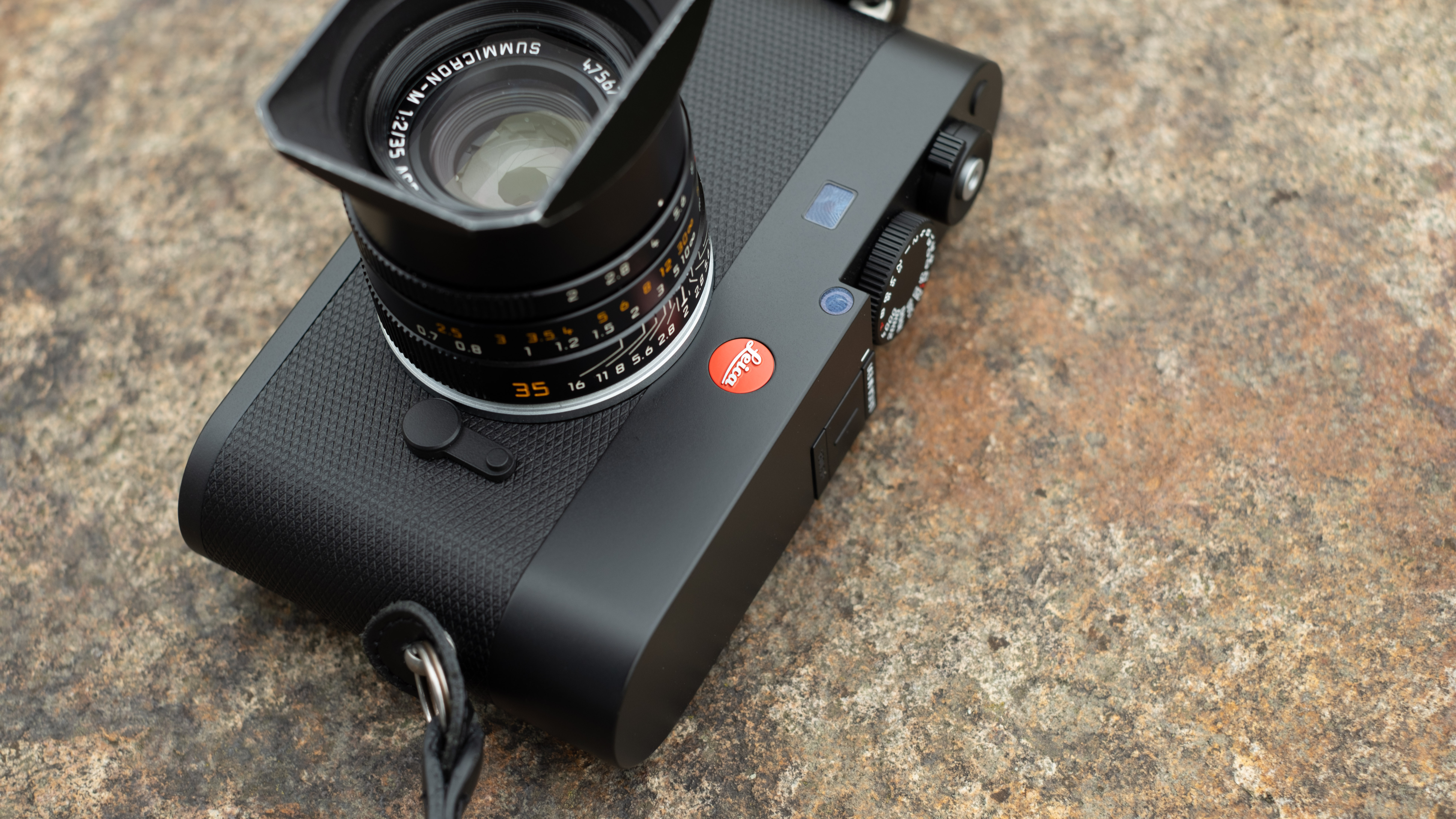 Leica M EV1 digital camera with lens attached on a stone surface