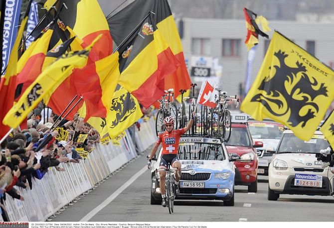 Fabian Cancellara dwarfed by the Belgian flags in the 2010 Tour of Flanders