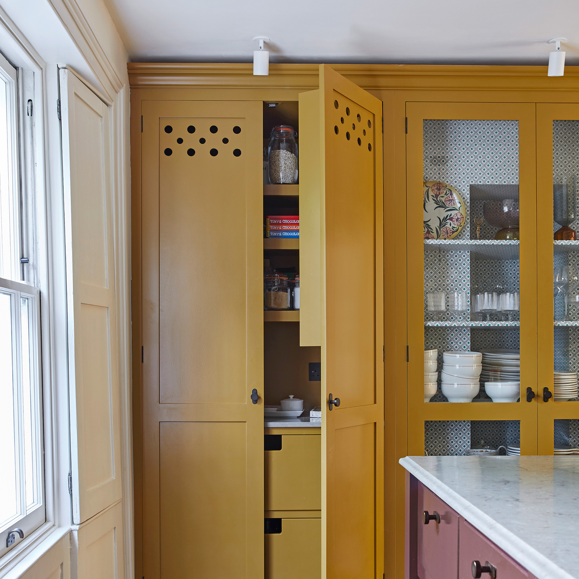 yellow full height larder cupboard in traditional kitchen