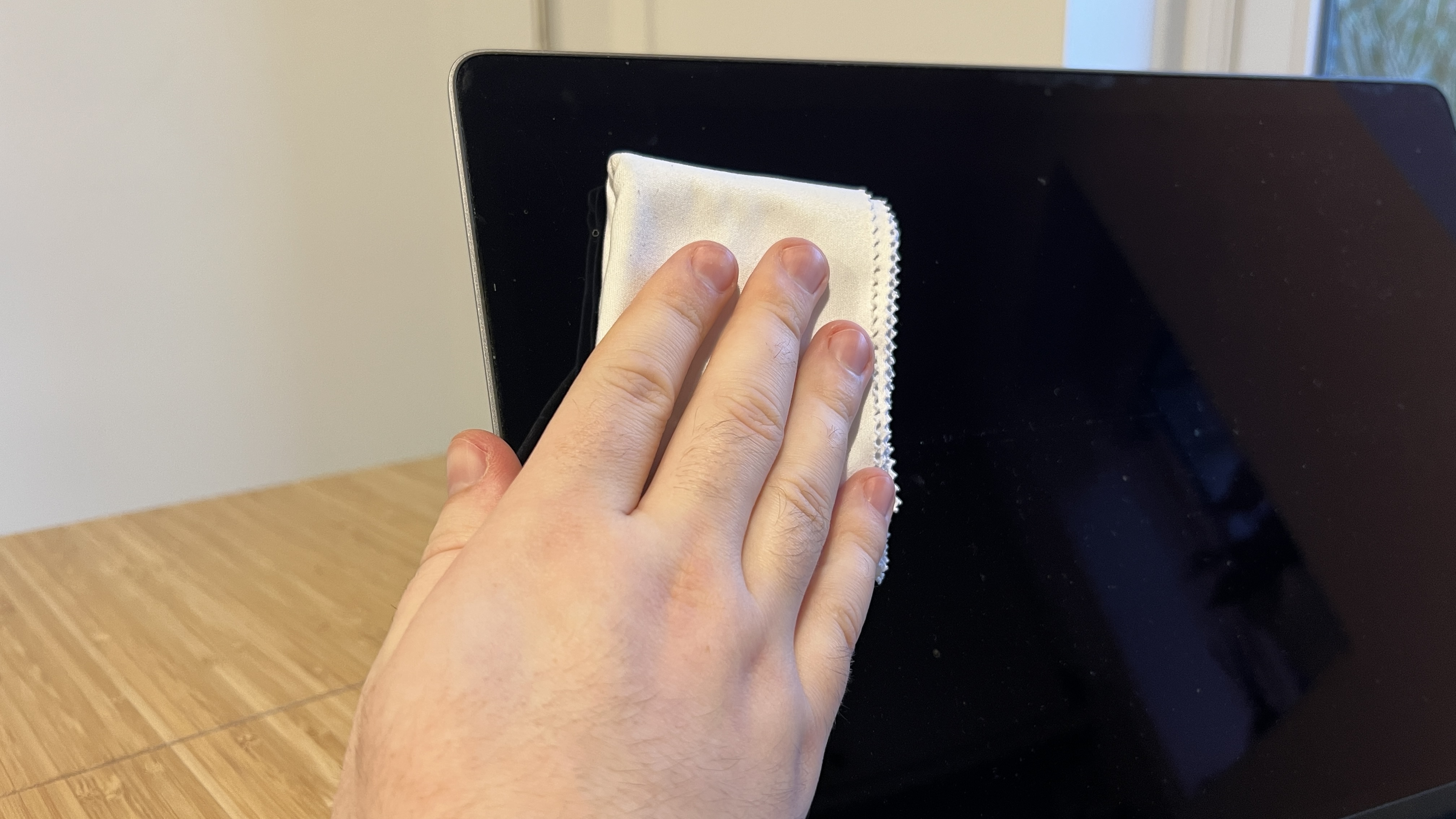 يتم مسح شاشة جهاز MacBook بقطعة قماش من الألياف الدقيقة