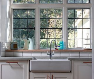 black crittall style windows in kitchen above white butler style sink