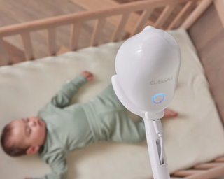 Cubo Ai Plus Smart Baby Monitor with baby sleeping in the cot
