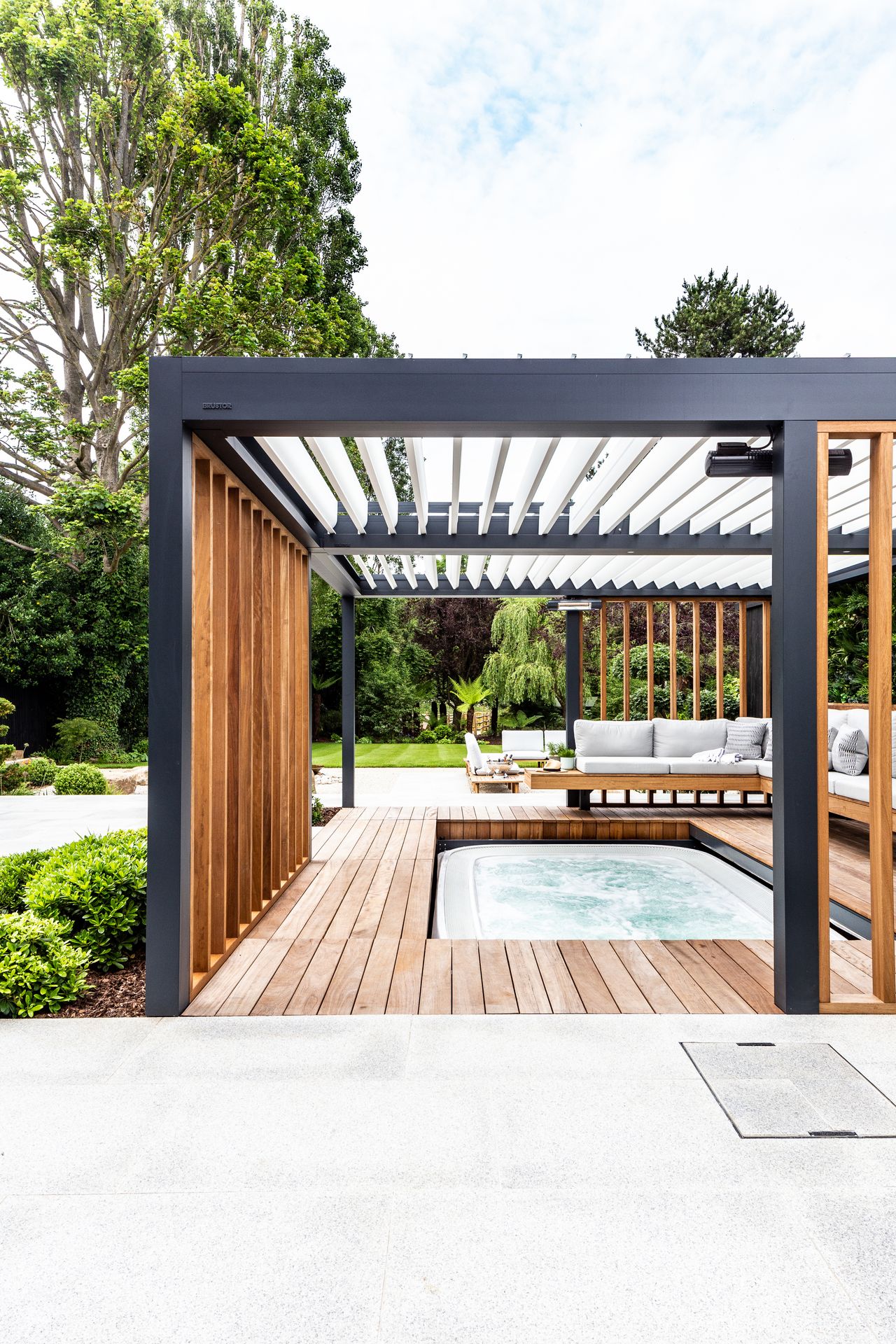 modern pergola with floating benchseat and decking that retracts to reveal hot tub