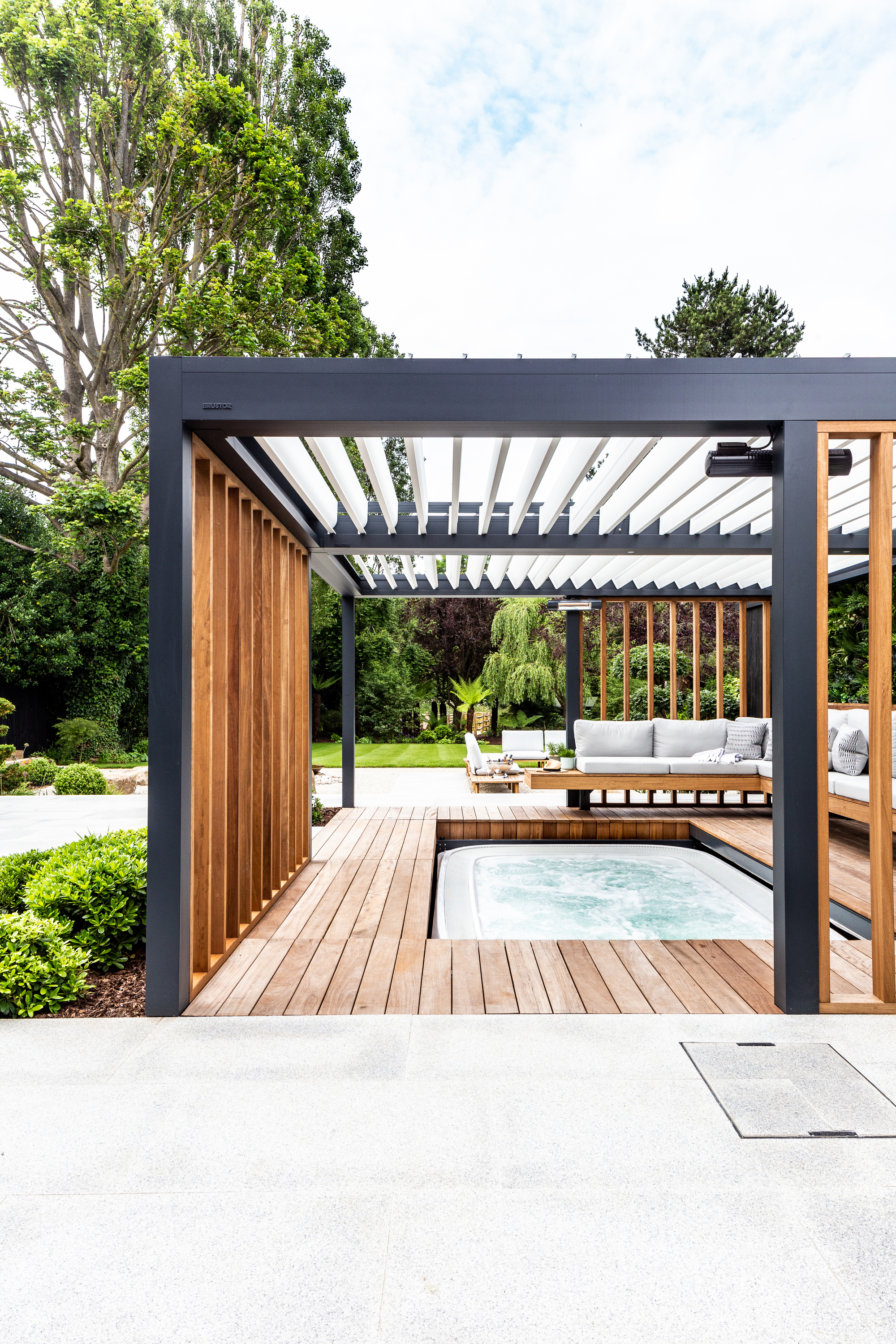 modern pergola with floating benchseat and decking that retracts to reveal hot tub