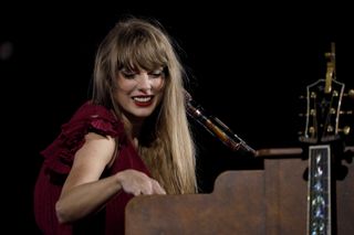 Taylor Swift sings behind a piano