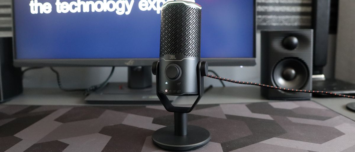 JBL Quantum Stream Studio microphone on a mouse mat in front of a monitor