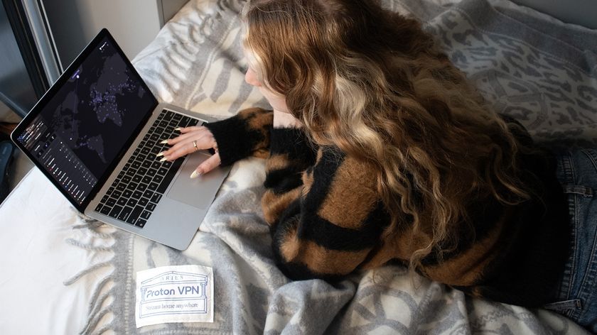 Girl on Proton VPN/Aries blanket looking on Proton VPN app on laptop screen - promo image