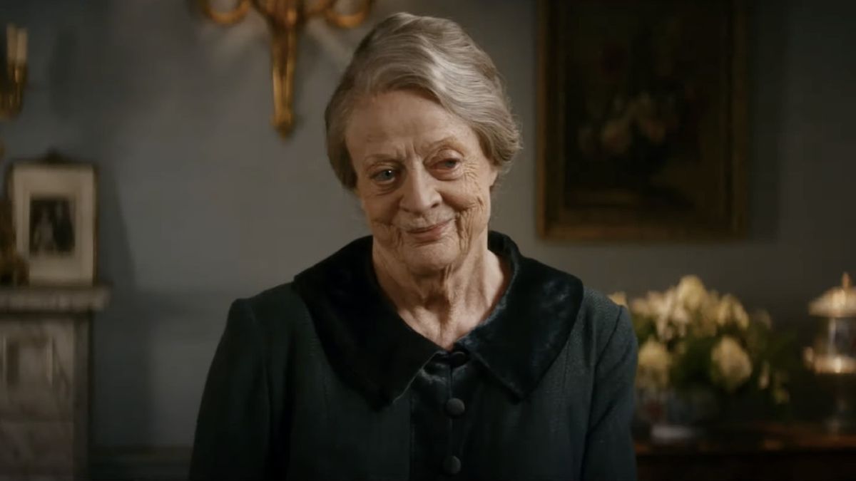 Dame Maggie Smith smiling in a sitting room in Downton Abbey: A New Era.