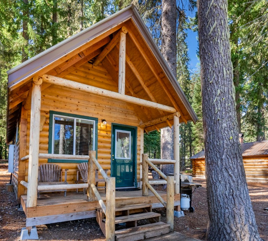 A quaint, tiny cabin at Shelter Cove Resort for glamping. The cabin has a small front porch and electricity.