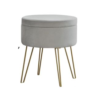 A gray circular storage ottoman with gold legs