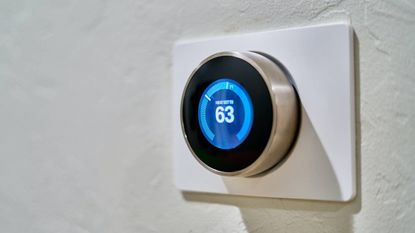 A smart thermostat placed on a wall, smart home tips