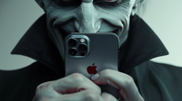 A person that looks like Dracula menacingly holding an iphone