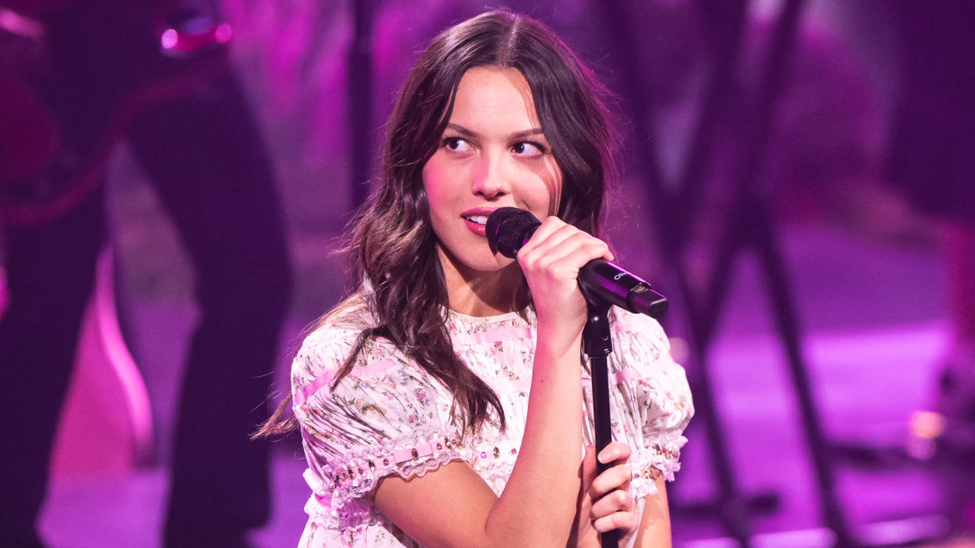Olivia Rodrigo performs on stage during an exclusive Billions Club Live show to celebrate the partnership between Spotify and FC Barcelona wearing a babydoll floral dress 