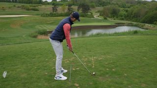 PGA pro Alex Elliott showing how to use alignment sticks in order to pick a specific target when golfing
