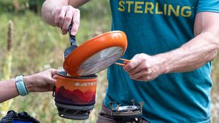 Jetboil vs MSR Windburner: a man cooking with a Jetboil stove