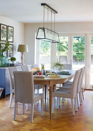 dining area with white woven chairs long wooden oval table french windows