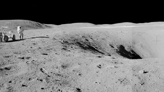 A wide angle shot of a crater on the moon, with an astronaut and a lunar rover off to the side